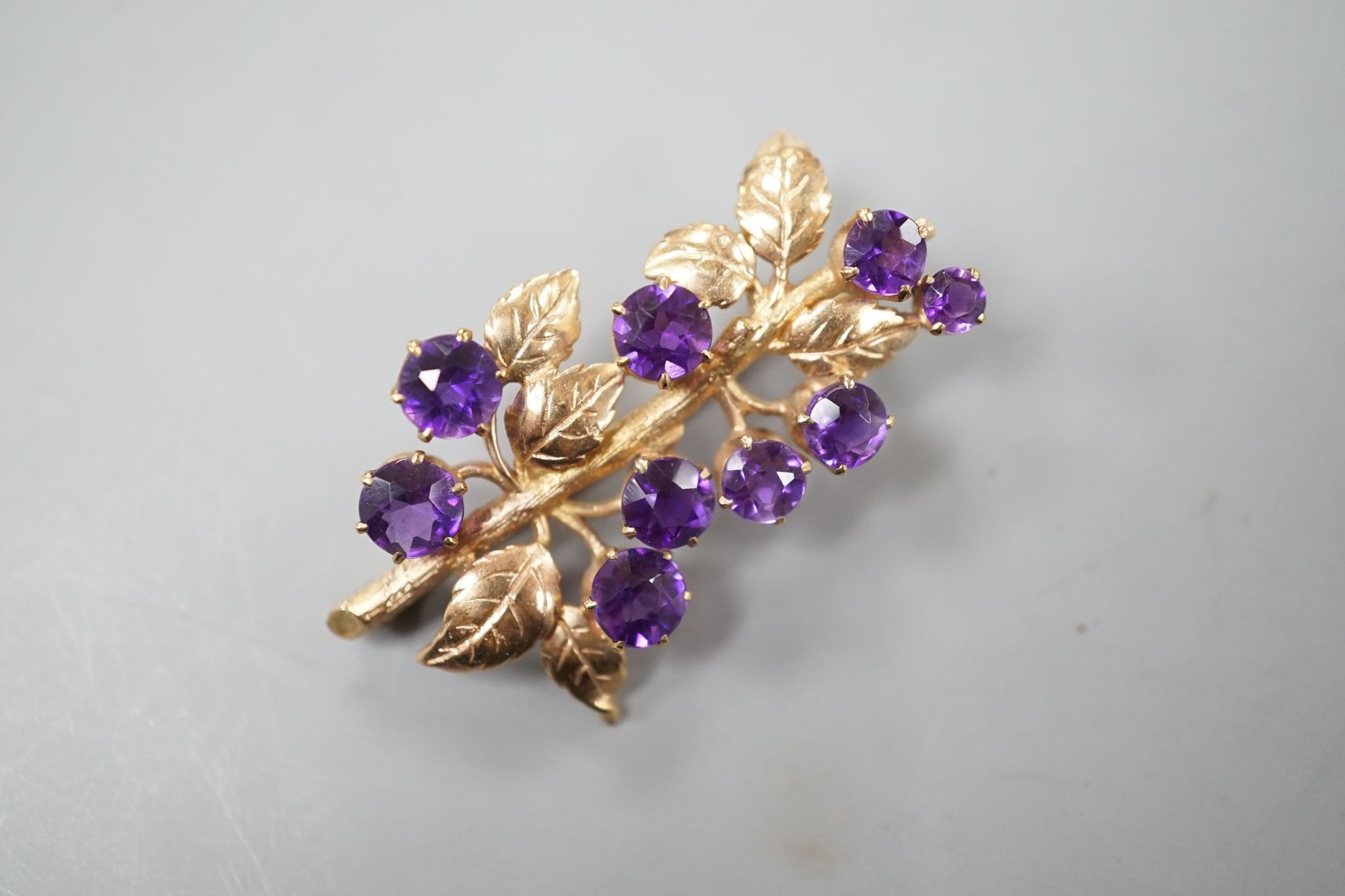 A modern 9ct gold and nine stone amethyst set spray brooch, 42mm, gross 7.6 grams, in fitted box.